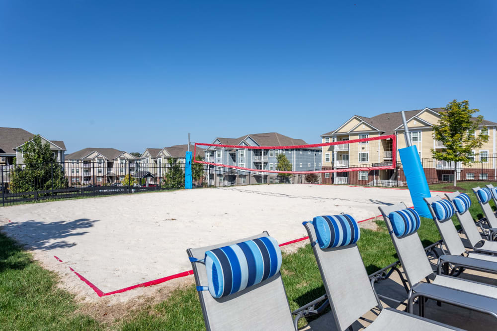 Lounge chairs next to the sand volleyball court at The Retreat at Arden Village Apartments in Columbia, Tennessee