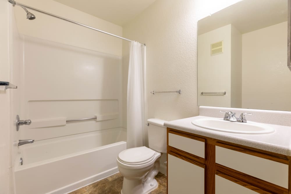 Bathroom with shower, tub and white countered vanity at Sterling Park Apartments in Brighton, Colorado