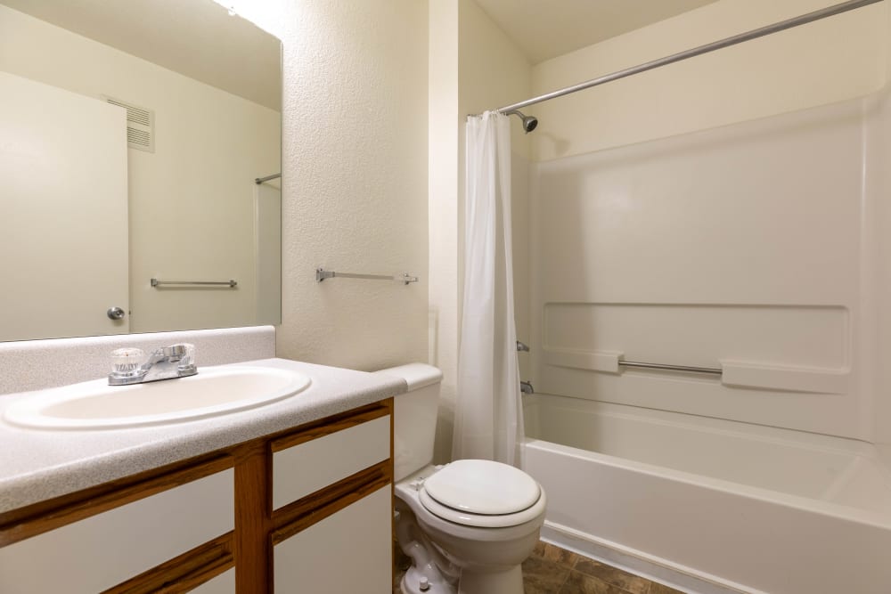 Bathroom with large vanity mirror and step in shower tub at Sterling Park Apartments in Brighton, Colorado