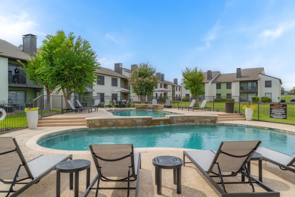 Sunloungers by the pool  at Leander Apartment Homes in Benbrook, Texas