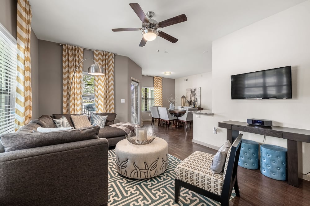 Bright living room with wood flooring and a large rug at Marquis on Lakeline in Cedar Park, Texas