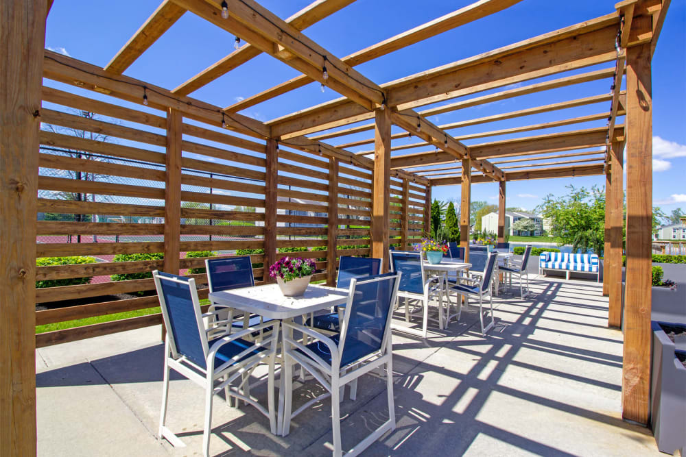 Outdoor seating next to the grilling area, under a pergola