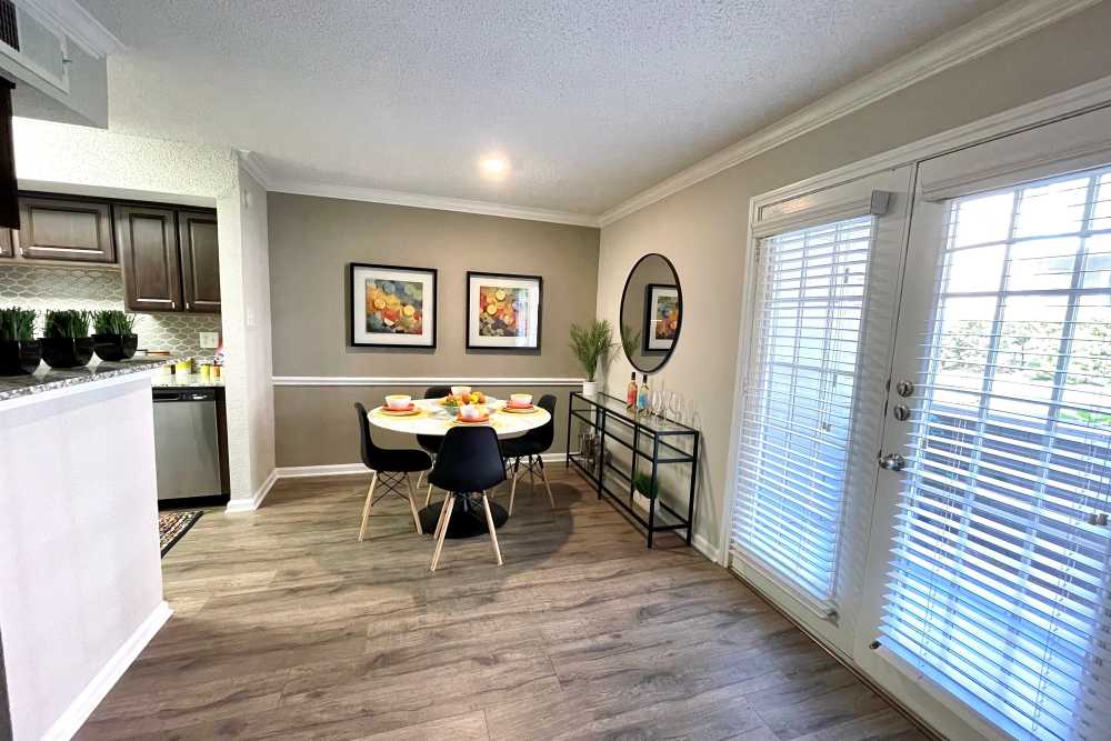 Bright Dining Area Featuring Round Table Set For Four, Black Dining Chairs, And Decorative Wall Art at The Abbey at Montgomery Park in Conroe, Texas
