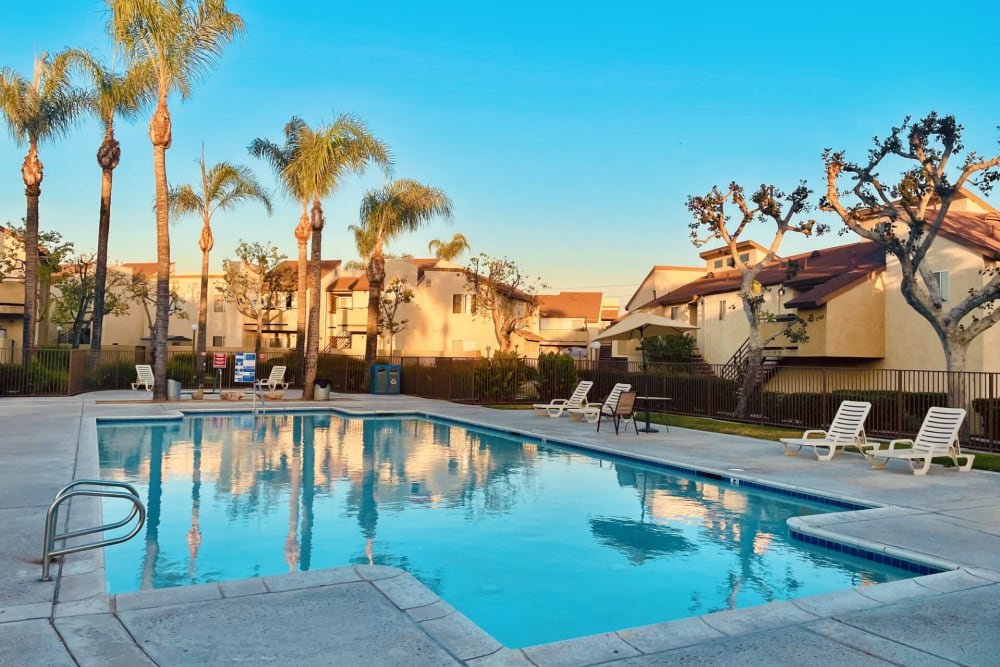 Deck chair around outdoor swimming pool at Peppertree Place Apartments in Riverside, California