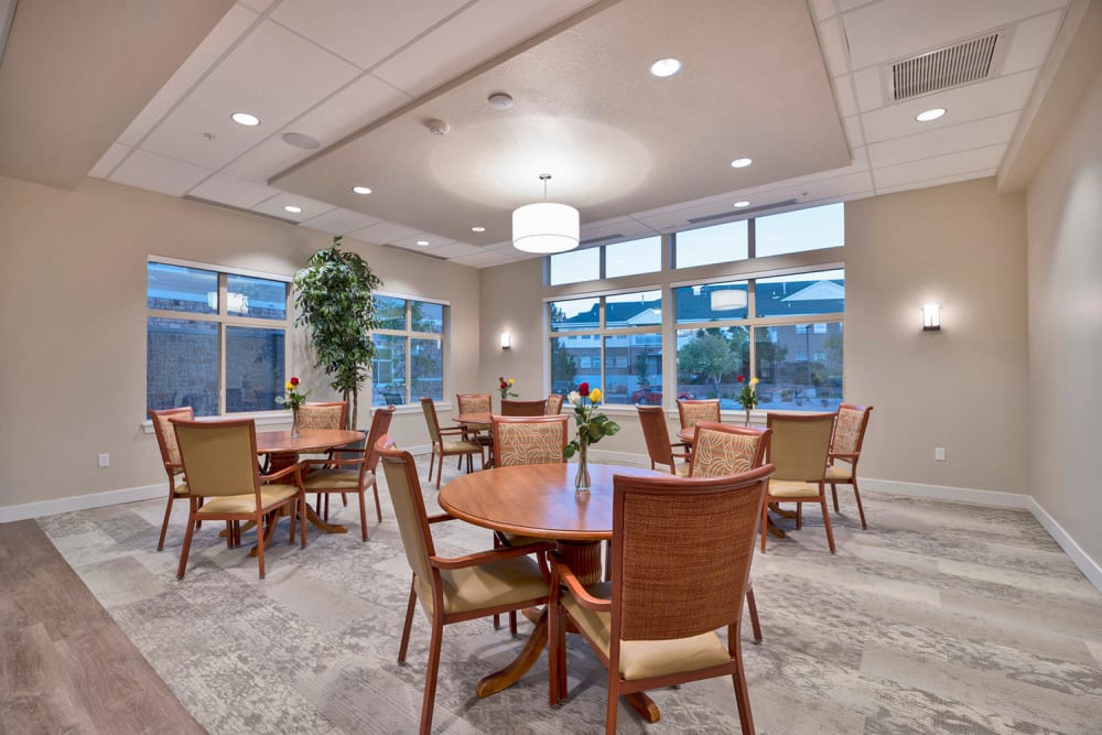 tables and chairs by a corner window at Crescent Senior Living in Sandy, Utah