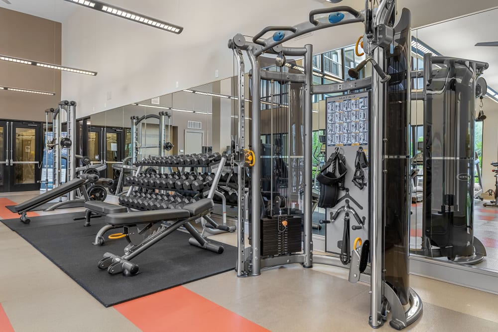 Assisted weight machine and weight benches in fitness room at Marq Uptown in Austin, Texas