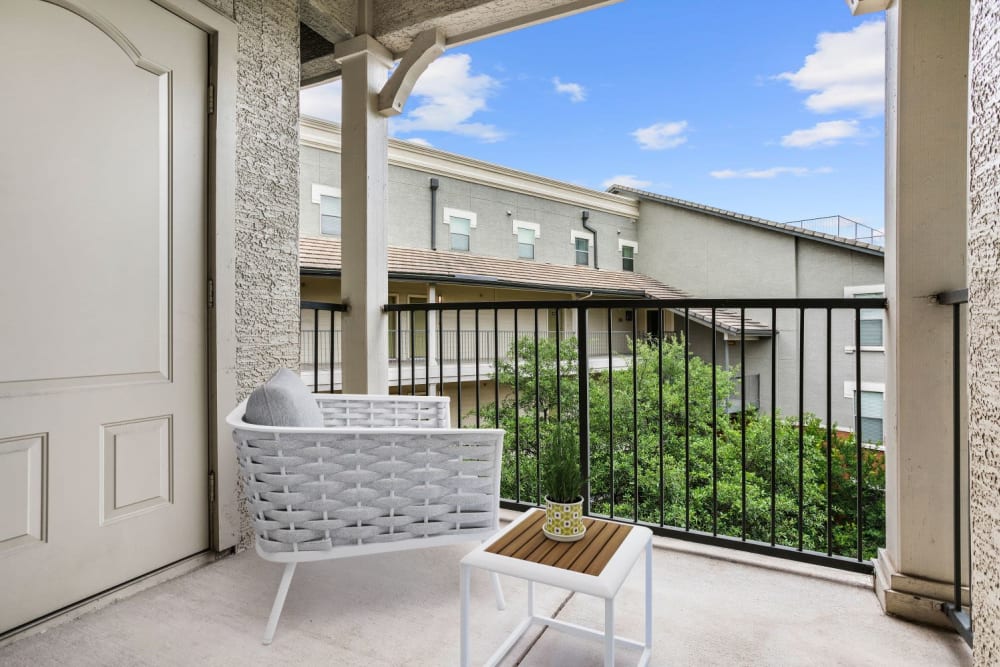 Private balcony with a view of the lake outside a model home at Olympus Las Colinas in Irving, Texas