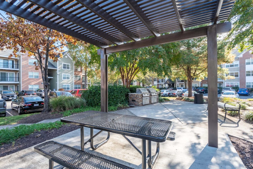 Picnic table with wooden sunshade structure at Abbotts Run Apartments in Alexandria, Virginia