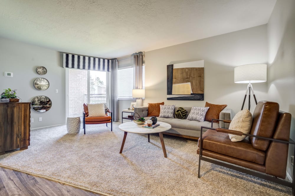 Living room with access to private balcony at Cherry Creek Apartments in Riverdale, Utah