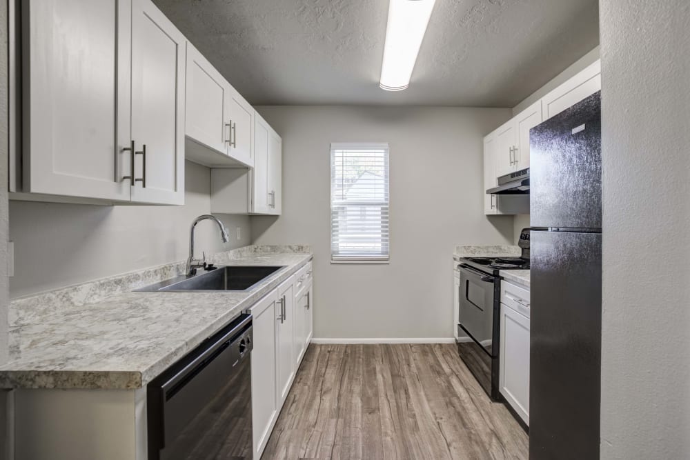 Kitchen with white cabinets and ample counter space at Cherry Creek Apartments in Riverdale, Utah