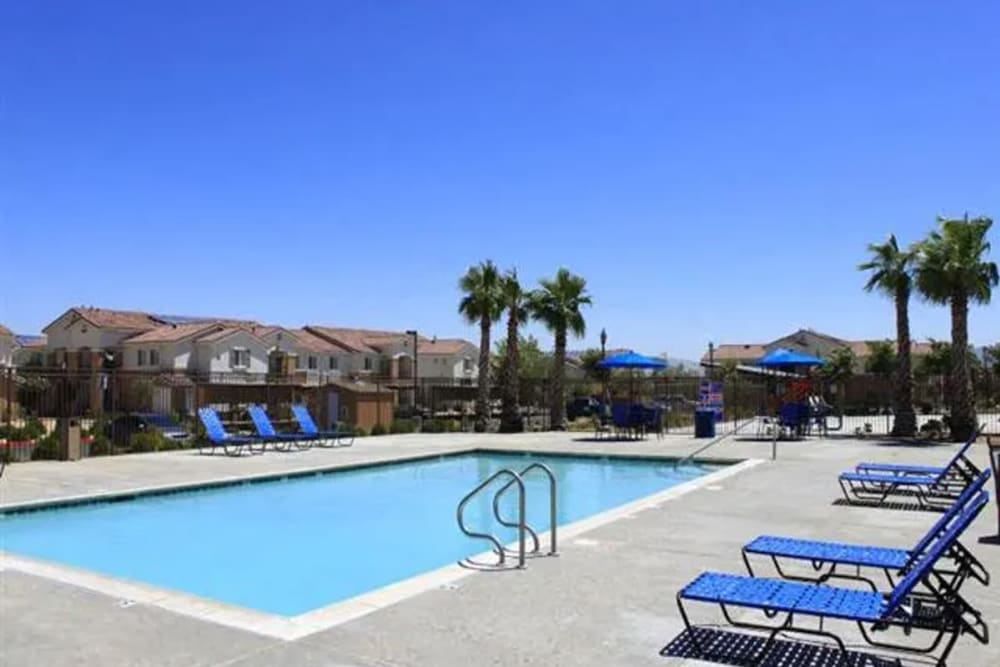 Lounge chairs by the resort-style swimming pool at Casa Bella in Victorville, California
