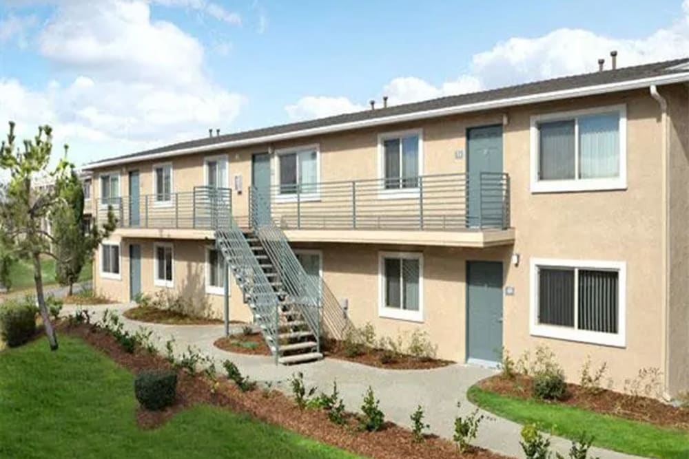 Exterior of an apartment with private patios and balconies at Casa Bella in Victorville, California