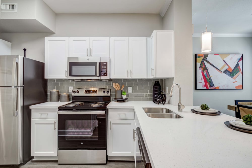 Kitchen featuring white cabinets and ample counter space at Signature Point Apartments in League City, Texas
