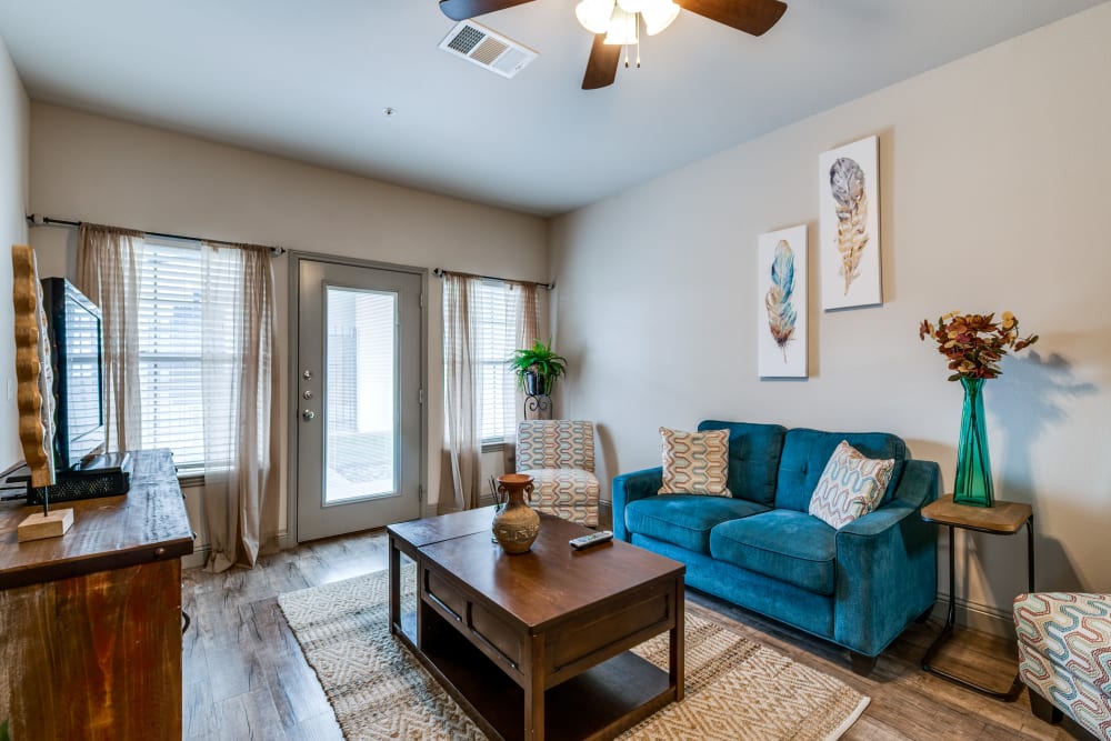 Living room with ceiling fan at Remi Apartment Homes in White Settlement, Texas