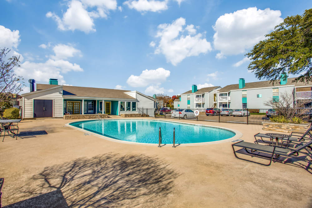 Swimming pool with nice chairs at Sagamore Apartment Homes in Benbrook, Texas
