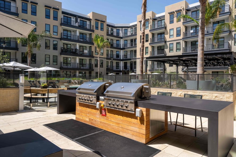 Gas grills and outdoor dining area in the courtyard at MV Apartments in Mountain View, California