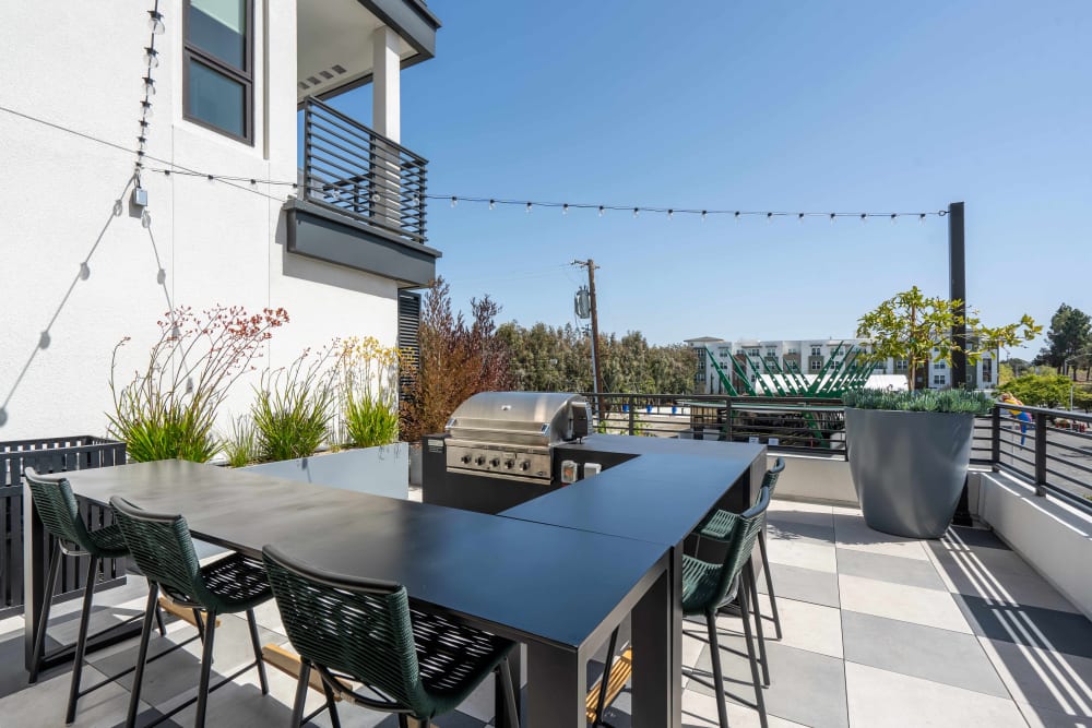 Outdoor terrace with a gas grill at MV Apartments in Mountain View, California