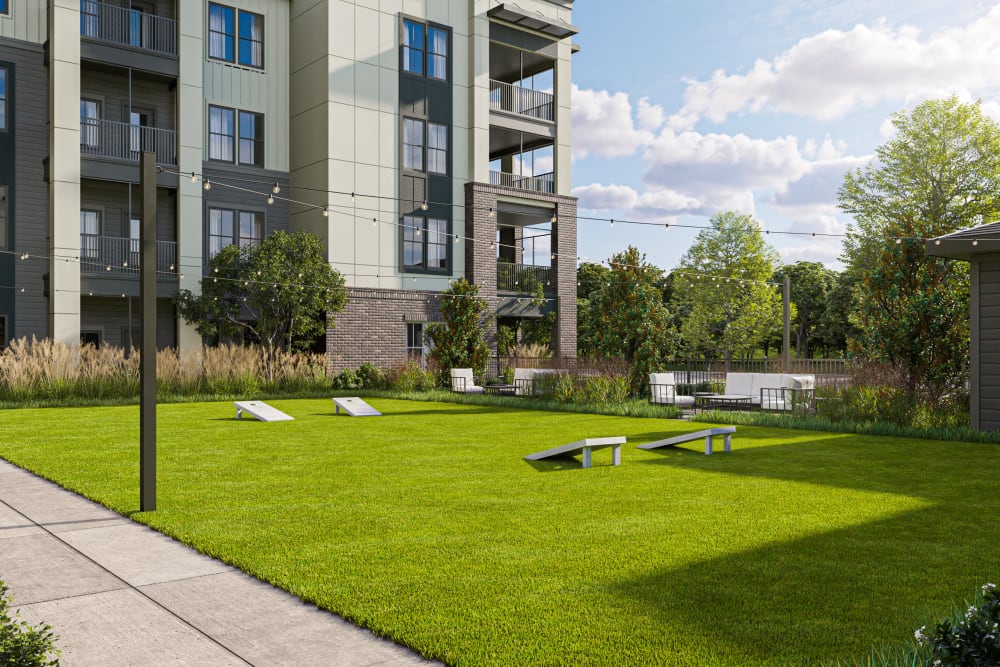 Luxury Apartments Belville, NC - Westport Lofts - Gaming Lawn with Cornhole Games, String Lights, and Maintained Landscaping
