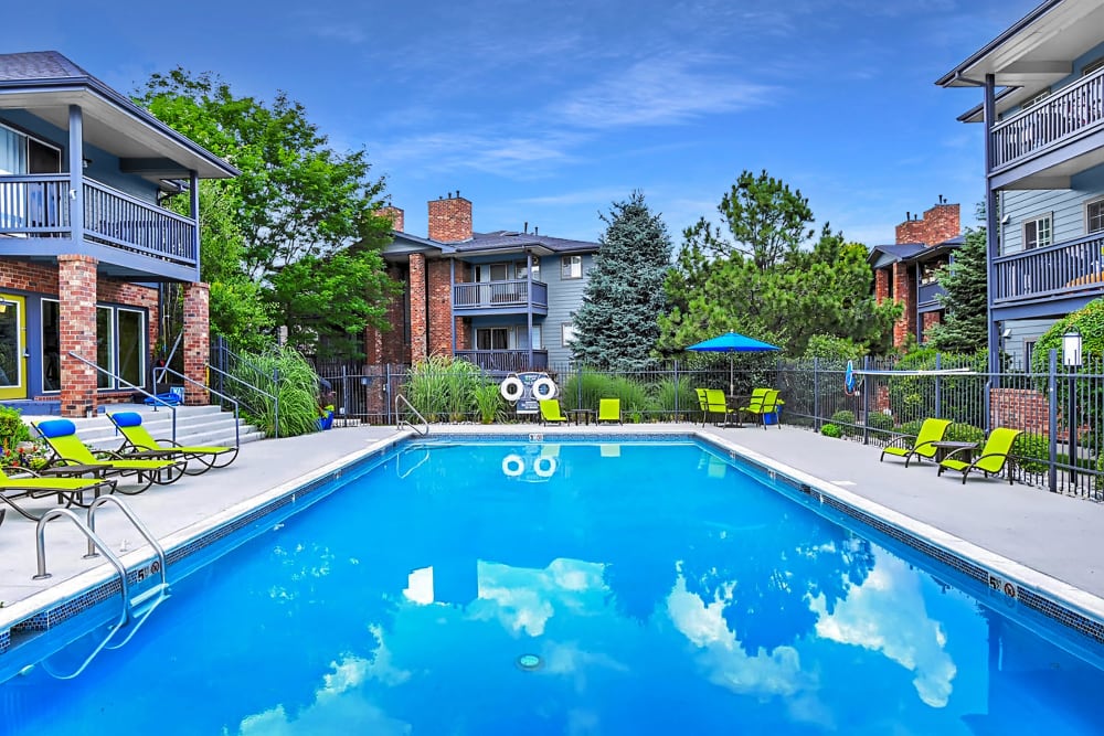 Swimming pool with a sundeck and lounge chairs at Arapahoe Club Apartments in Denver, Colorado