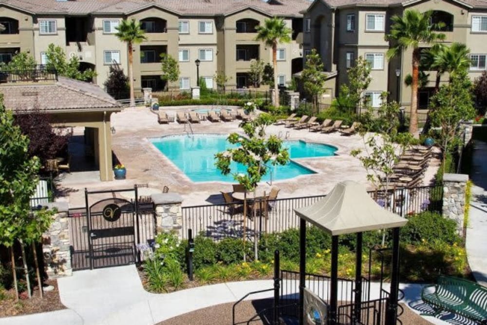 Pool and deck with lounge chairs at Villas At Villaggio in Modesto, California