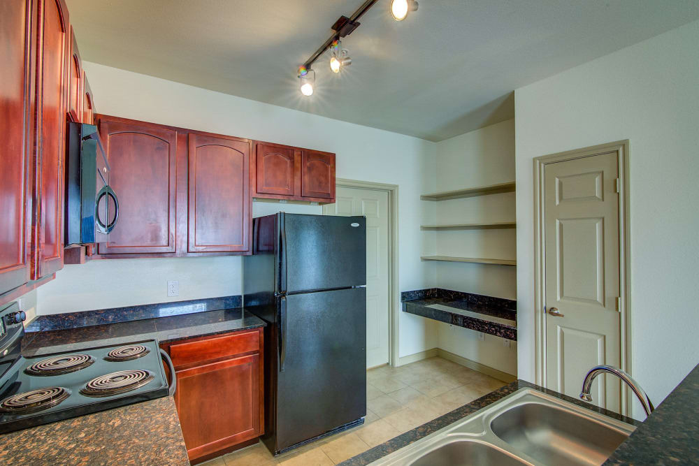 Kitchen with black appliances at Estates at Canyon Ridge in San Antonio, Texas