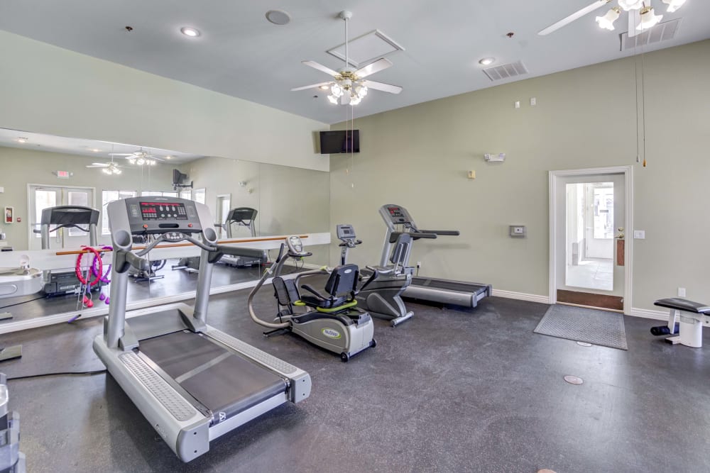 Fitness center at Whispering Palms Apartments in North Las Vegas, Nevada features a variety of workout equipment.