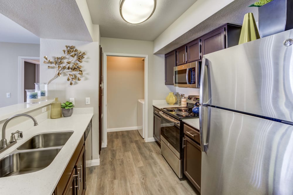 Kitchen in an apartment at Ascent at Silverado in Las Vegas, Nevada features stainless steel appliances and a double sink.