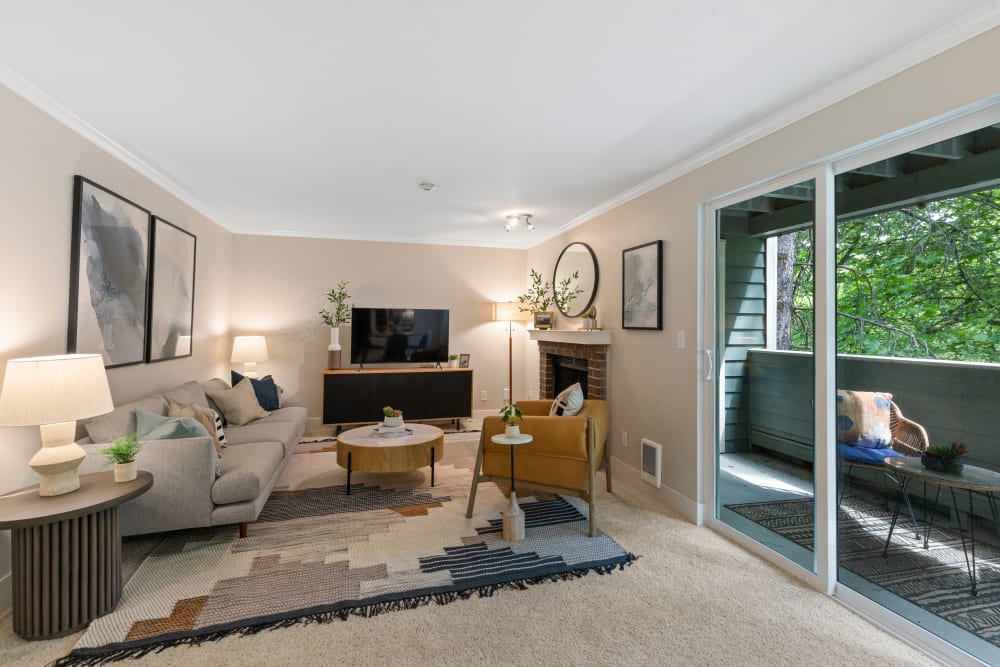 Spacious living room with a private balcony and plush carpeting at Skyline Redmond in Redmond, Washington