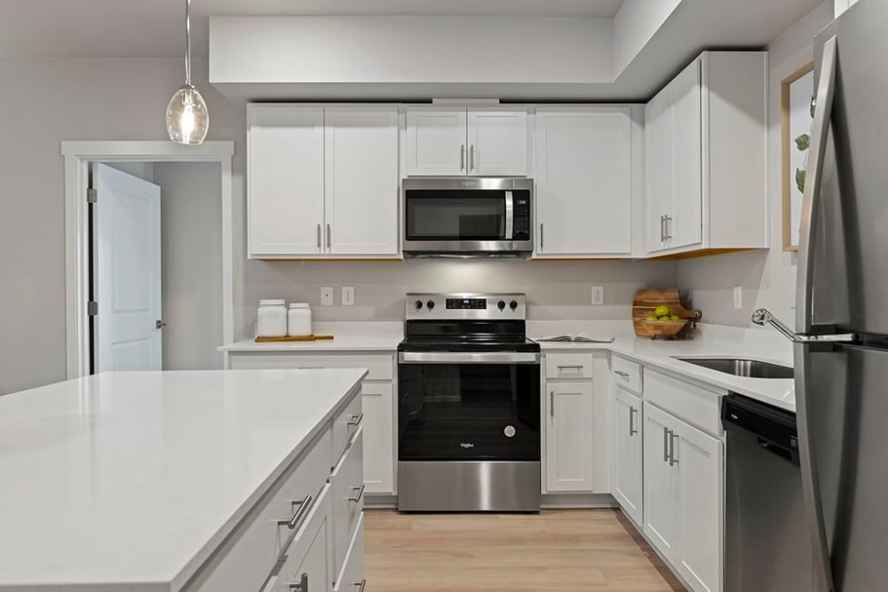White cupboards and stainless-steel appliances in an apartment kitchen at Wyndstone Apartments in Yelm, Washington