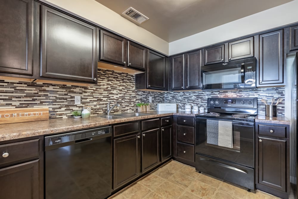 Kitchen with espresso cabinets and black appliances at Regency Lakeside Apartment Homes in Omaha, Nebraska
