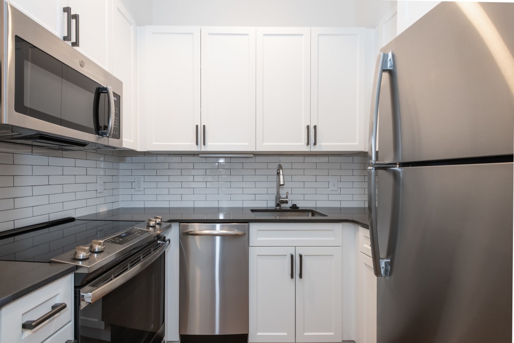 Kitchen with white cabinets and stainless-steel appliances at One India Street Apartments in Boston, Massachusetts