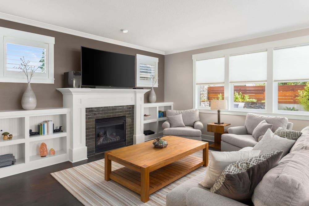 Apartment living room with large area rug, sectional, and television at The Avenue at 3060 in Atlanta, Georgia