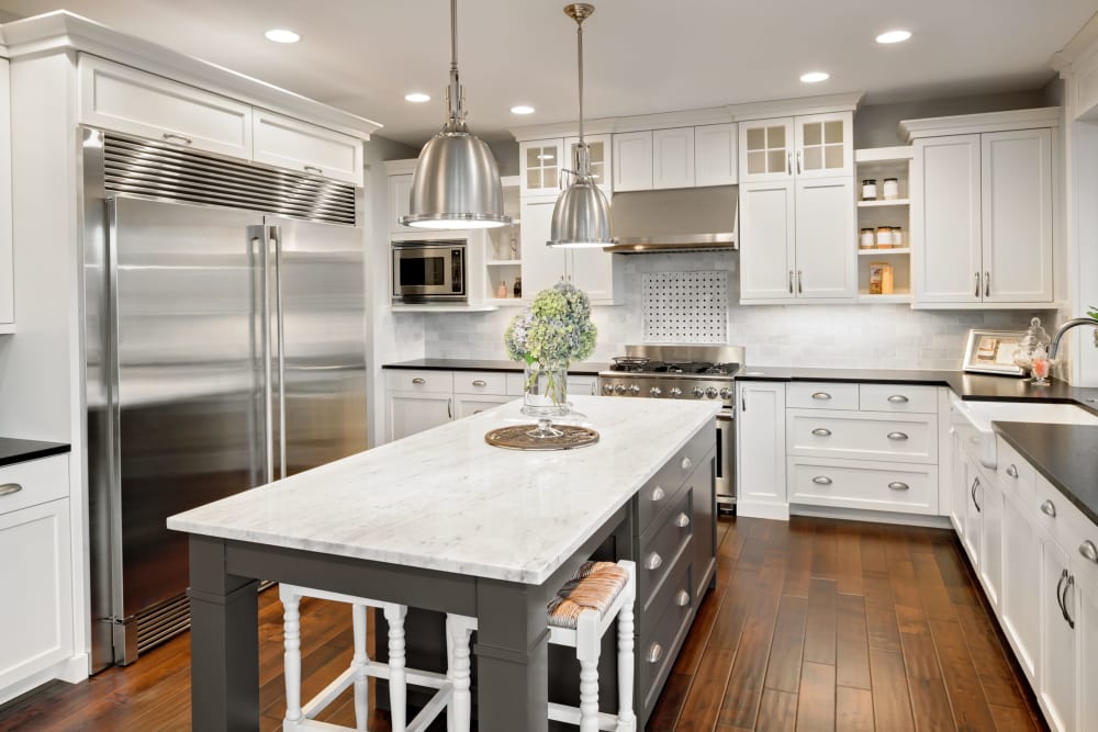 Apartment kitchen with hardwood floors and white granite counters at The Avenue at 3060 in Atlanta, Georgia