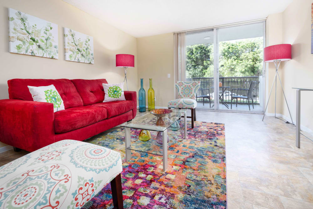 A furnished living room with a sliding glass door to the balcony at Forest Place in North Miami, Florida