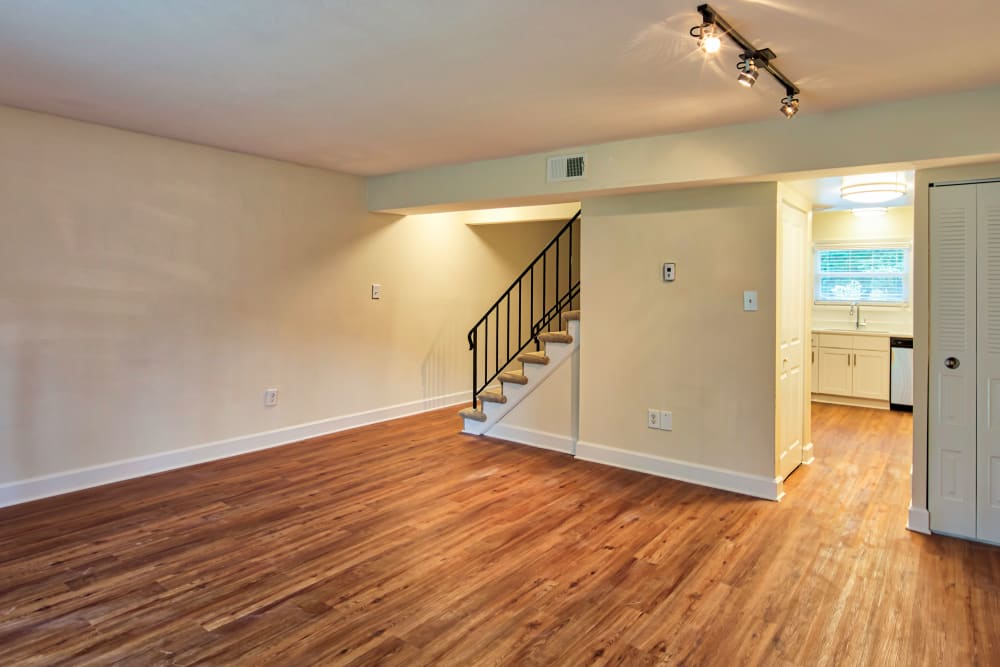 Dark wood flooring in an apartment living room and a staircase at Millspring Commons in Richmond, Virginia