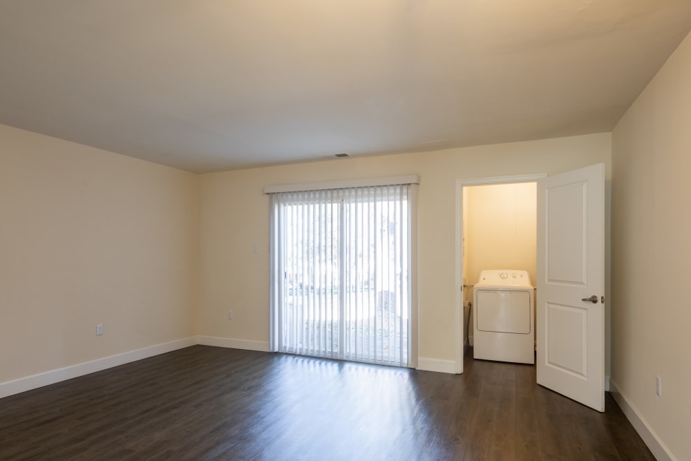 An apartment living room with the door open to the laundry room at Millspring Commons in Richmond, Virginia