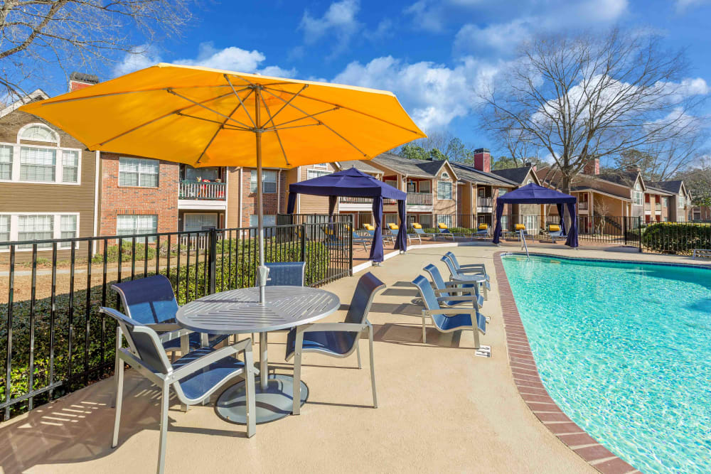 Outdoor, poolside seating with an umbrella at Parc at 1695 in Norcross, Georgia