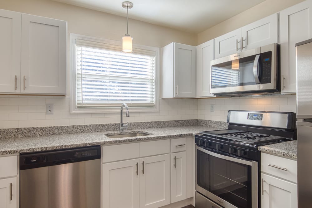 Granite countertops and stainless-steel appliances in an apartment kitchen at Millspring Commons in Richmond, Virginia