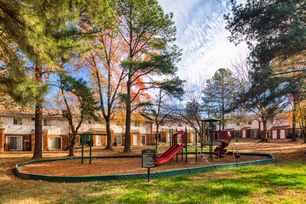 A playground surrounded by trees at Millspring Commons in Richmond, Virginia