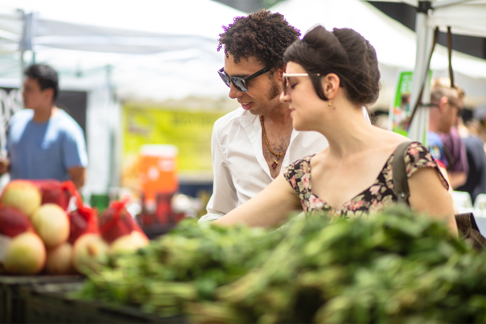 A couple shopping for produce at an outdoor market at Museum Tower in Los Angeles, California