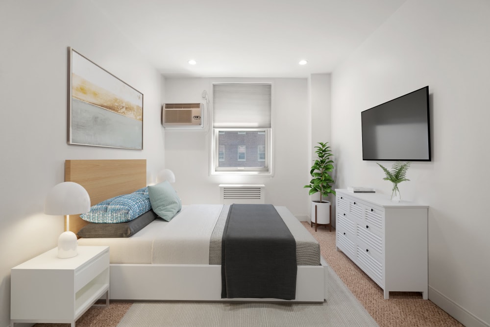 Three bedroom bedroom with a bed and dresser at Camelot Court in Brighton, Massachusetts
