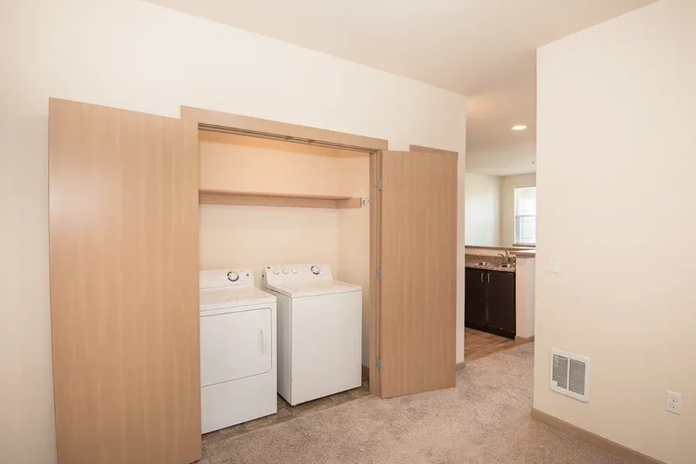 In-unit washer and dryer with extra linen storage at Bella on Canyon in Puyallup, Washington