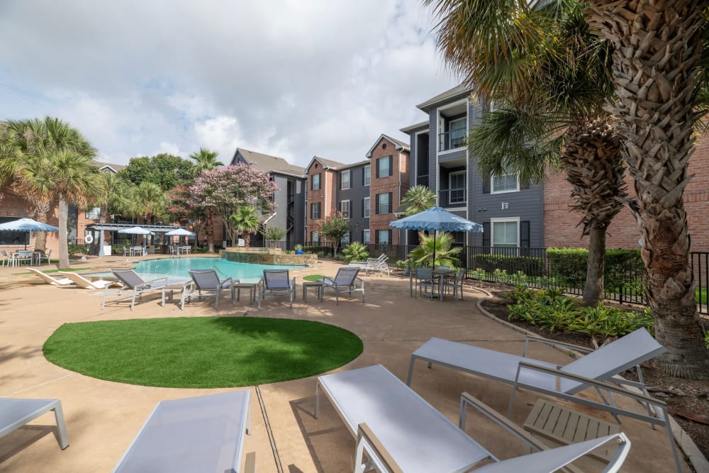 The community pool and surrounding apartments at Compass at Windmill Lakes in Houston, Texas