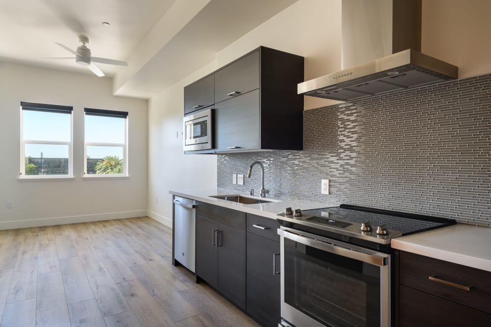 Model kitchen with tile backsplash at 16 Powerhouse Apartments in Sacramento, California