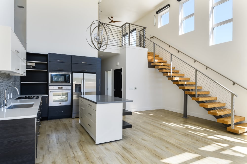 Open floor plan featuring staircase and kitchen at 16 Powerhouse Apartments in Sacramento, California