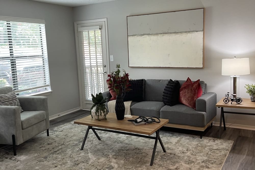 A model apartment living room with a couch, arm chair, coffee table and side table at Chapel Creek in Doraville, Georgia