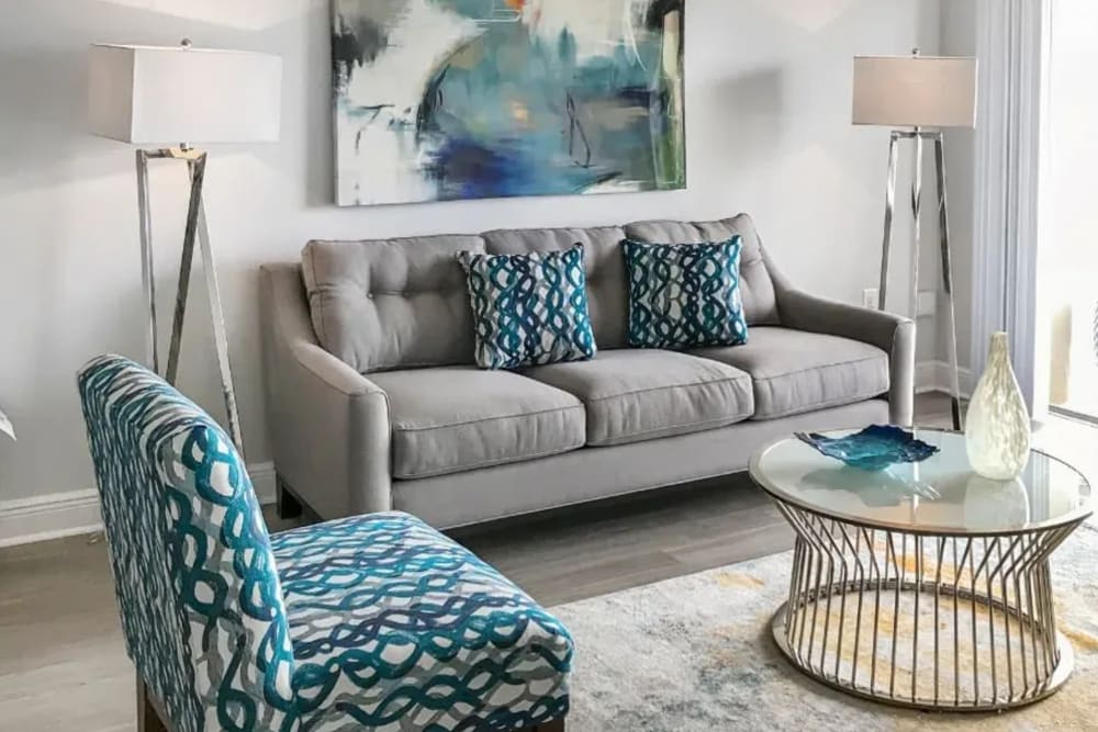 A furnished living room with a couch, side chair, coffee table and rug at Marina Del Mar in Sunny Isles Beach, Florida