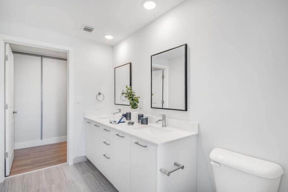 A double vanity and two mirrors in a large apartment bathroom at Marina Del Sol in Sunny Isles Beach, Florida