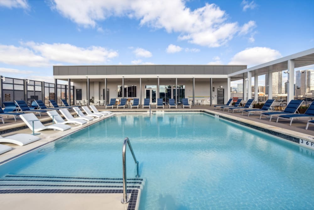 Rooftop pool with lounge chairs and grilling area at The Margaret at Riverfront in Dallas, Texas
