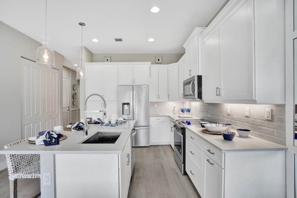 Spacious apartment kitchen with white cabinets and stainless-steel appliances at Solera at Avalon Trails in Delray Beach, Florida